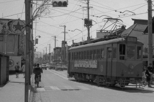 「ながい間ありがとうございました」との看板を掲げて走る路面電車の写真
