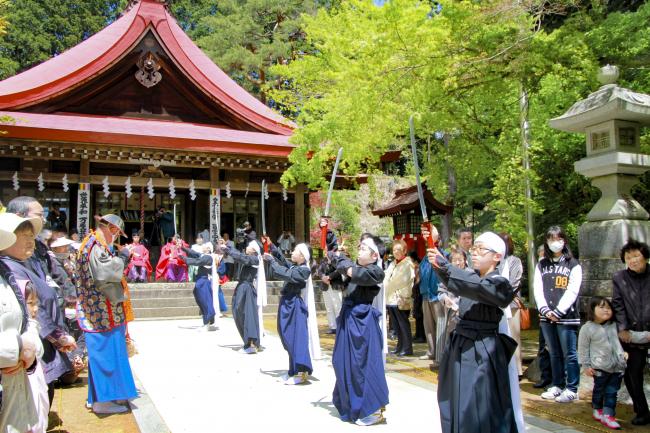 高く剣を掲げて剣舞を踊る子供たちの写真