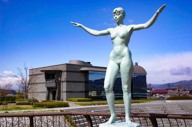 梁川美術館を背景にした広瀬川の橋の銅像の写真