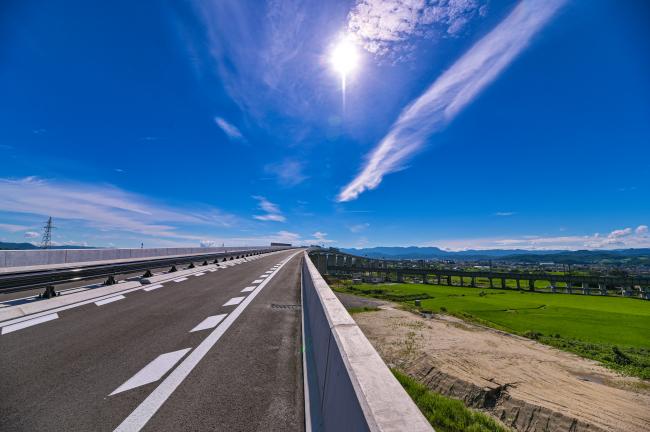 東北中央自動車道と青い空の写真