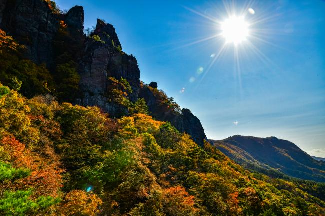 紅葉シーズンの霊山と太陽の光の写真