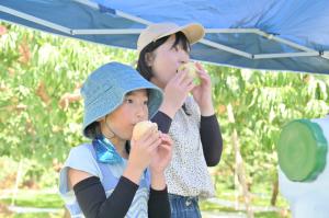 桃を食べる親子の写真