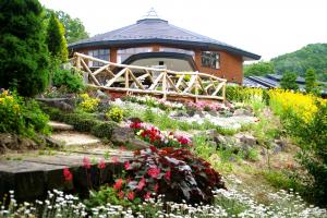 つきだて花工房の建物と庭園に咲く沢山の花の写真