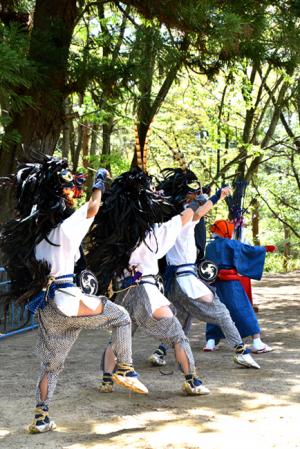 愛宕山と獅子舞を舞う人々の写真